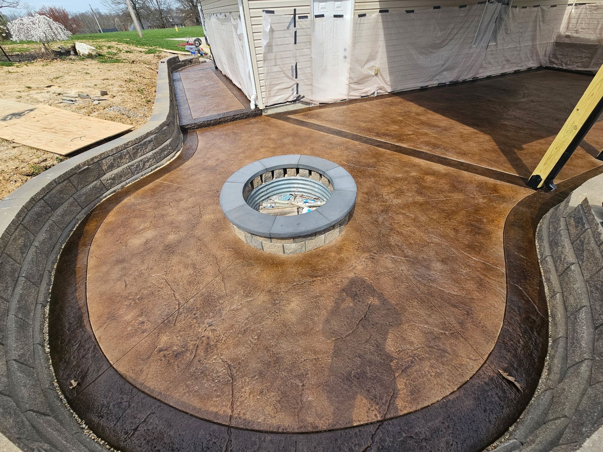 A concrete patio with a fire pit in the middle