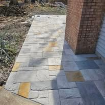 A stone sidewalk leading to a brick building.