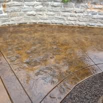 A close up of a concrete floor with a brick wall in the background.