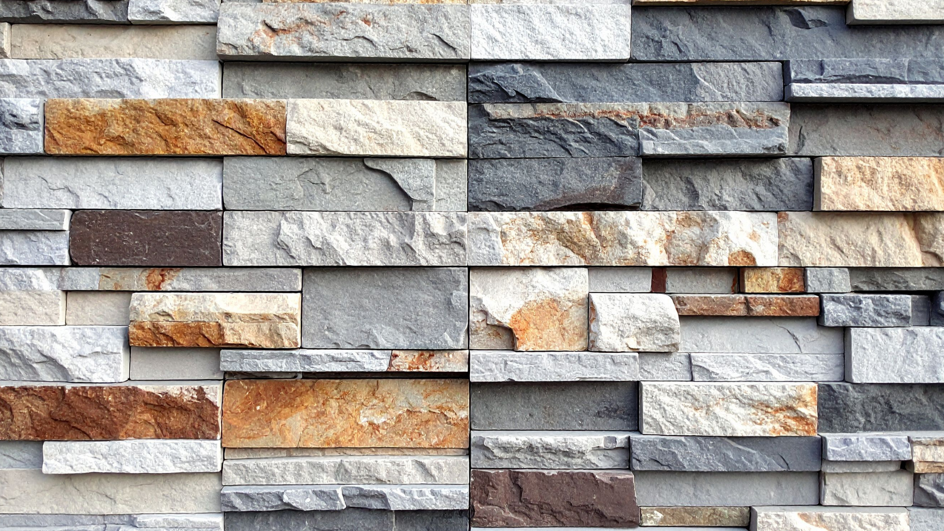 Stone wall with a layered, textured design in shades of brown, gray, and white.