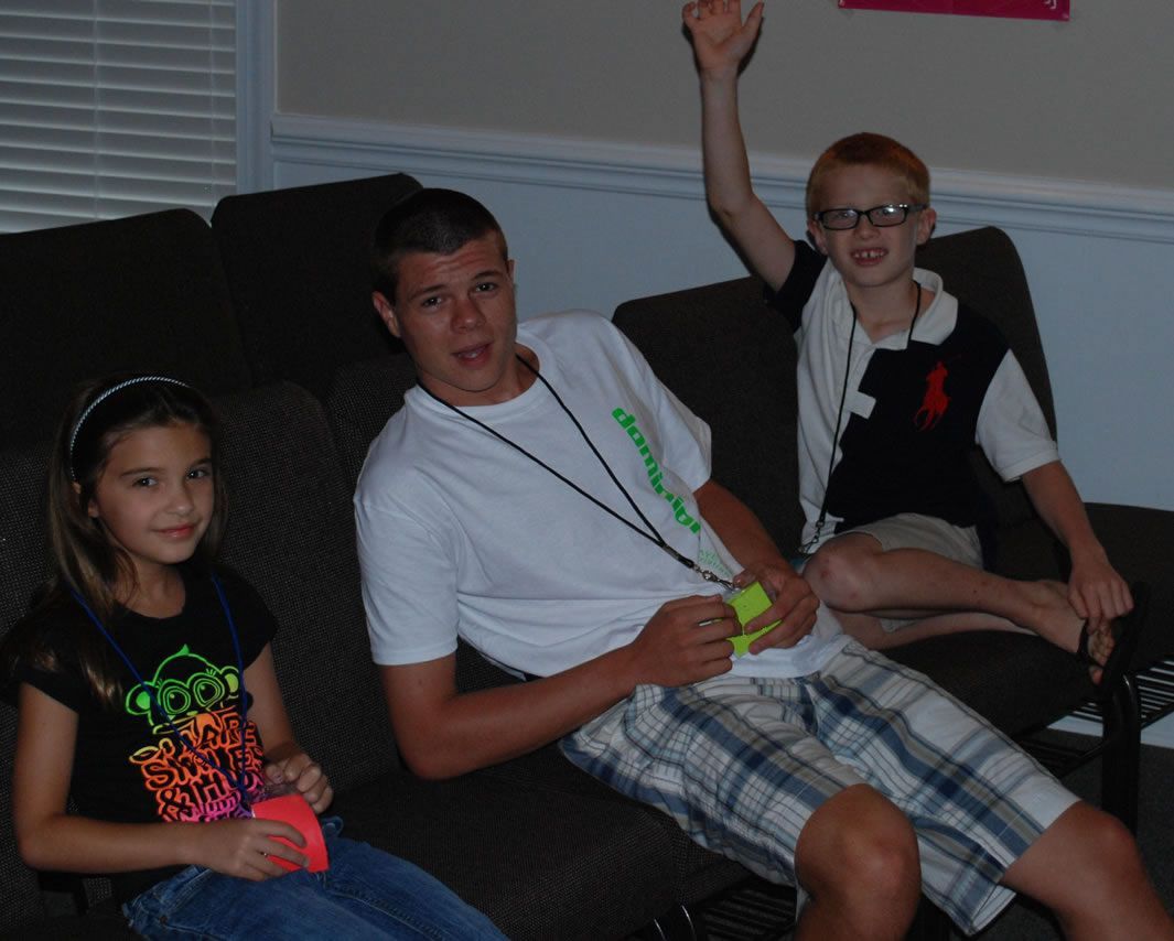 A boy and two girls are sitting on a couch