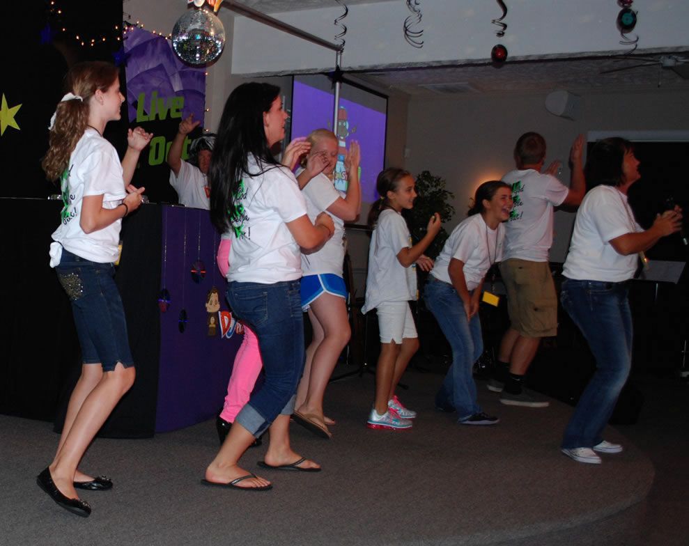 A group of people are dancing in front of a sign that says love