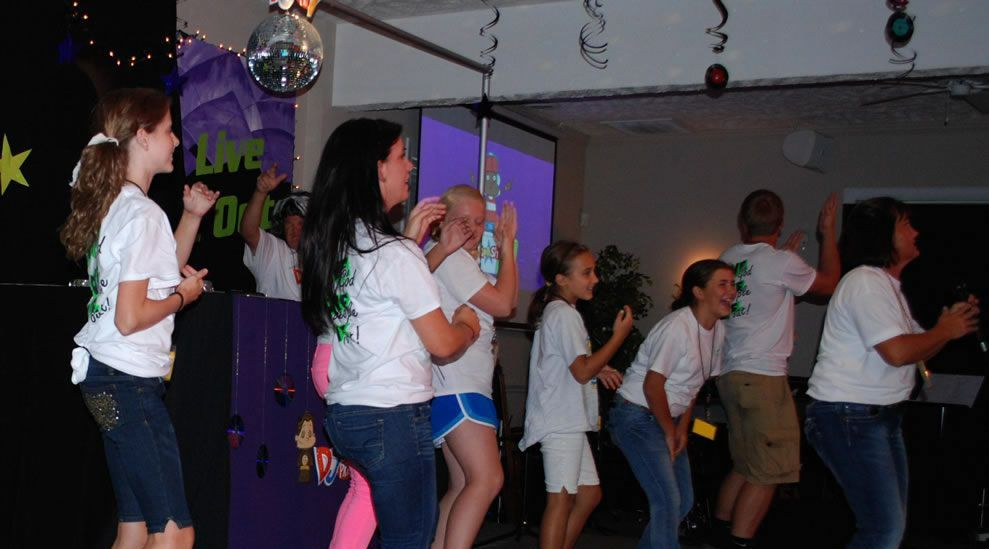A group of people are dancing in front of a sign that says love