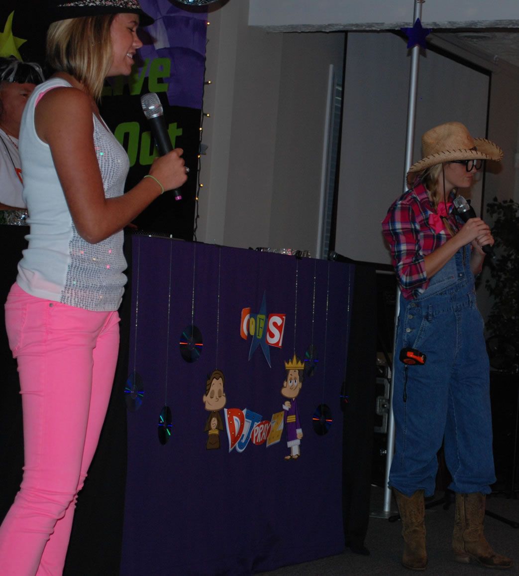 A woman in a cowboy hat is speaking into a microphone