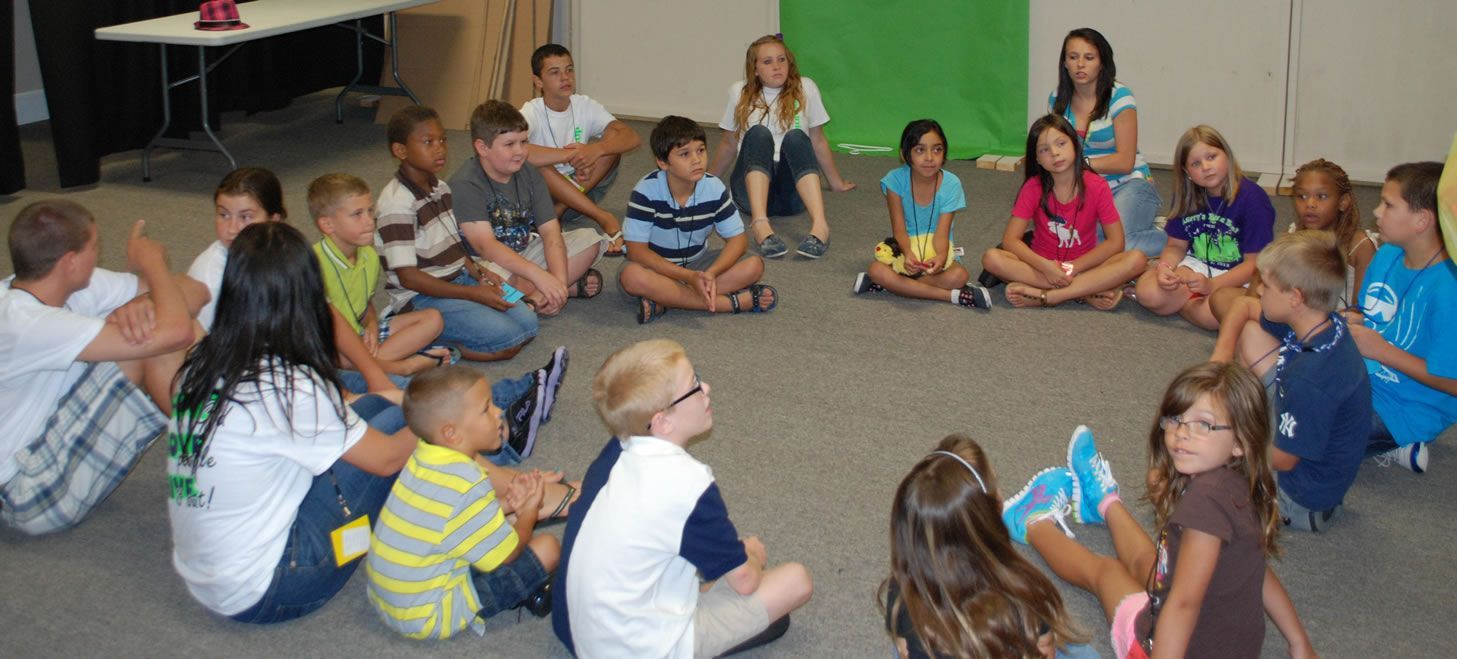A group of children are sitting in a circle on the floor