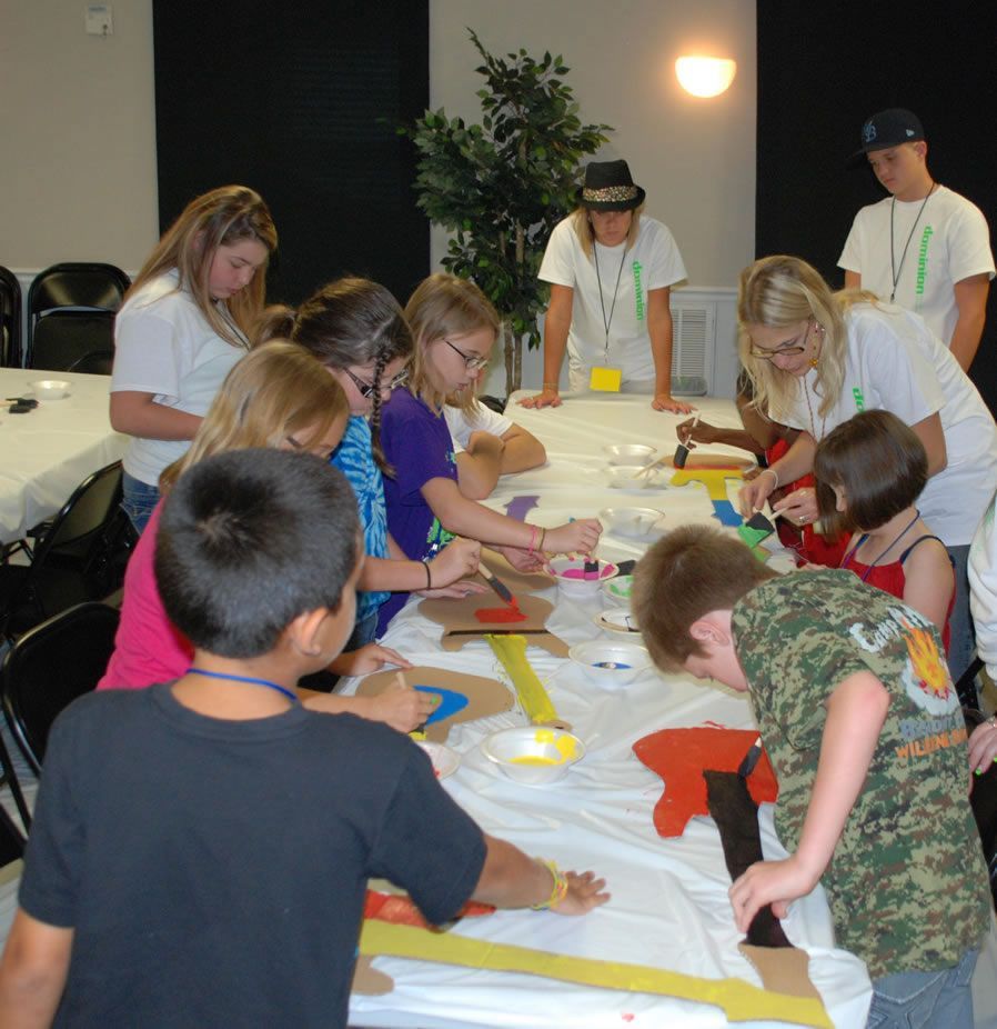 A group of children are sitting around a table playing with toys