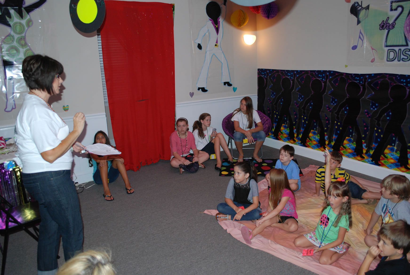 A woman is giving a presentation to a group of children
