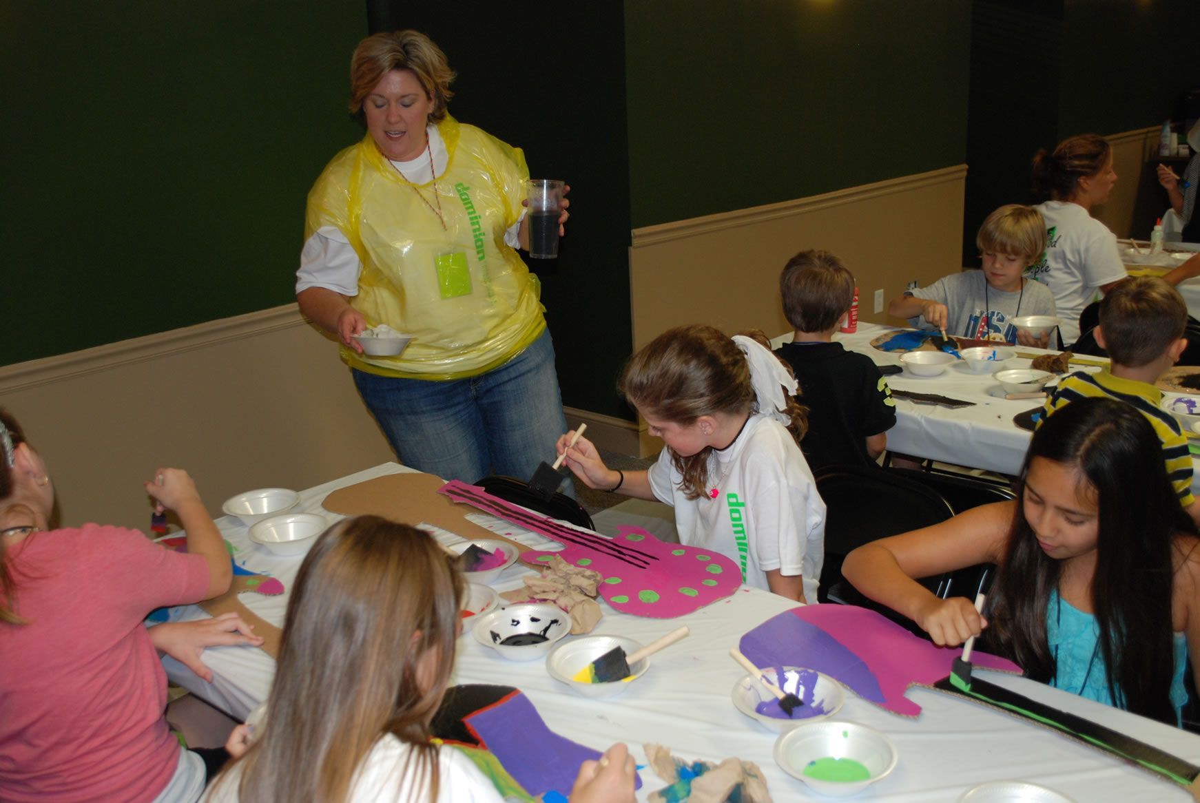 A group of children are sitting around a table painting