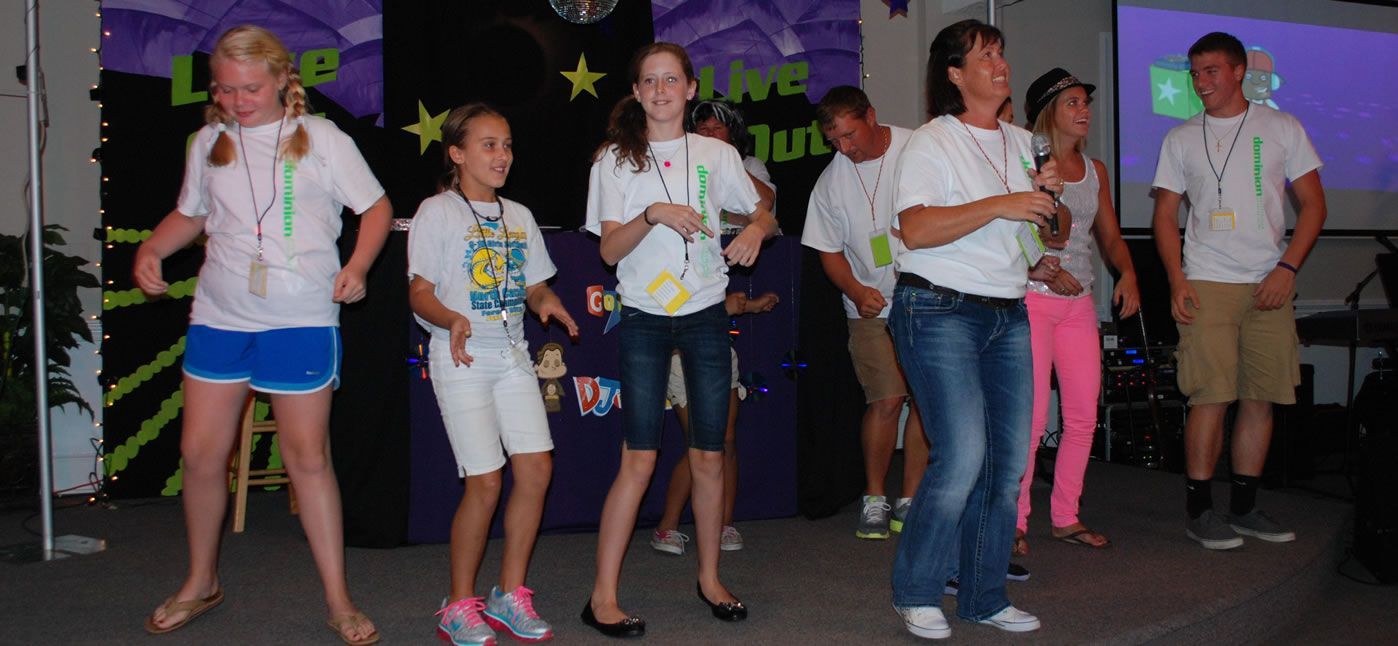 A group of people are dancing in front of a sign that says june