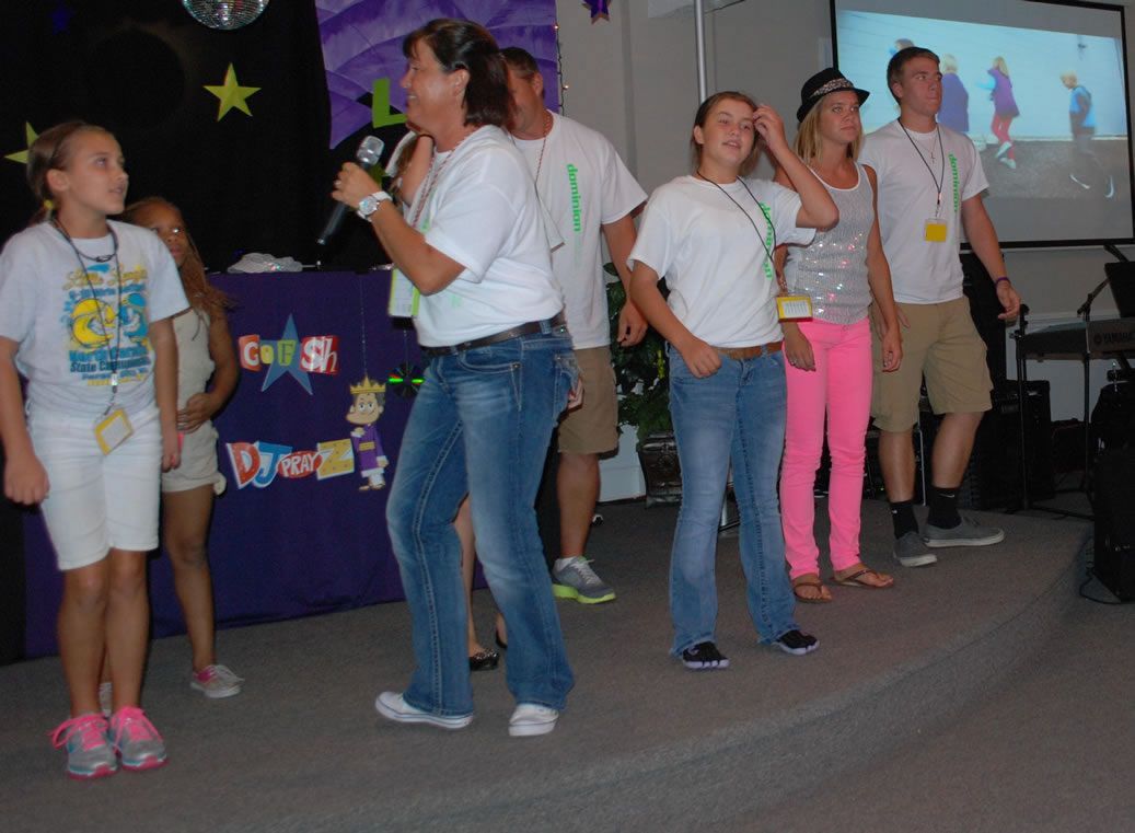 A group of people are standing in front of a sign that says 