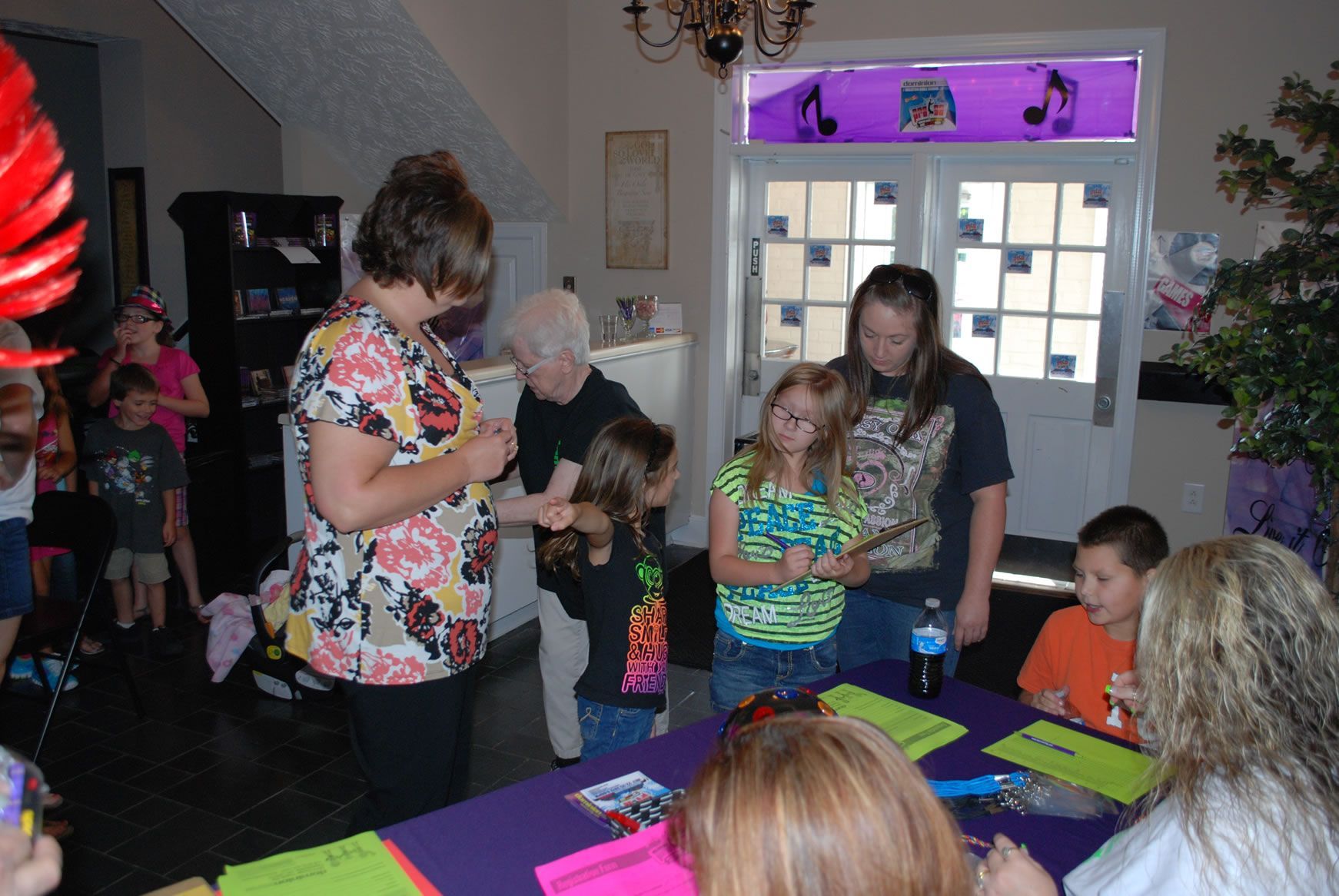 A group of people are gathered around a table with papers on it