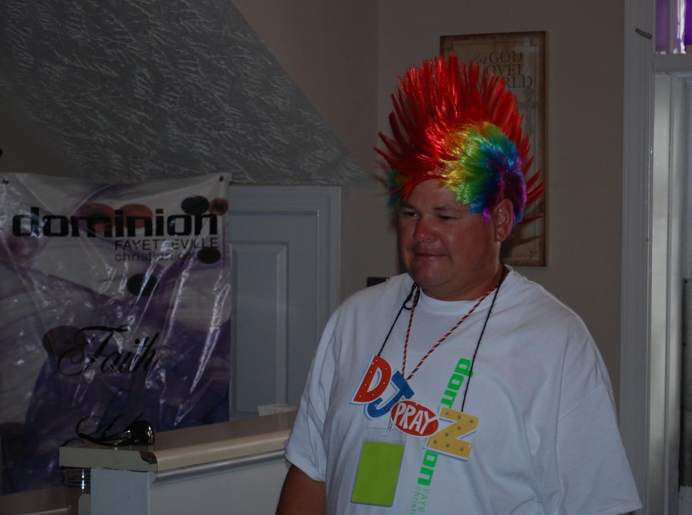 A man wearing a rainbow mohawk and a dj pear shirt