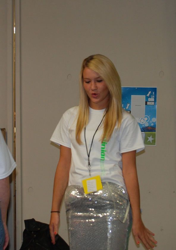 A woman in a white shirt with a lanyard around her neck that says ' brian ' on it