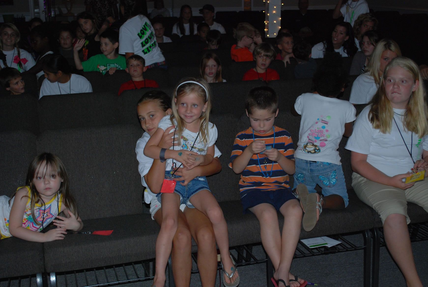 A group of children are sitting in a theater watching a movie