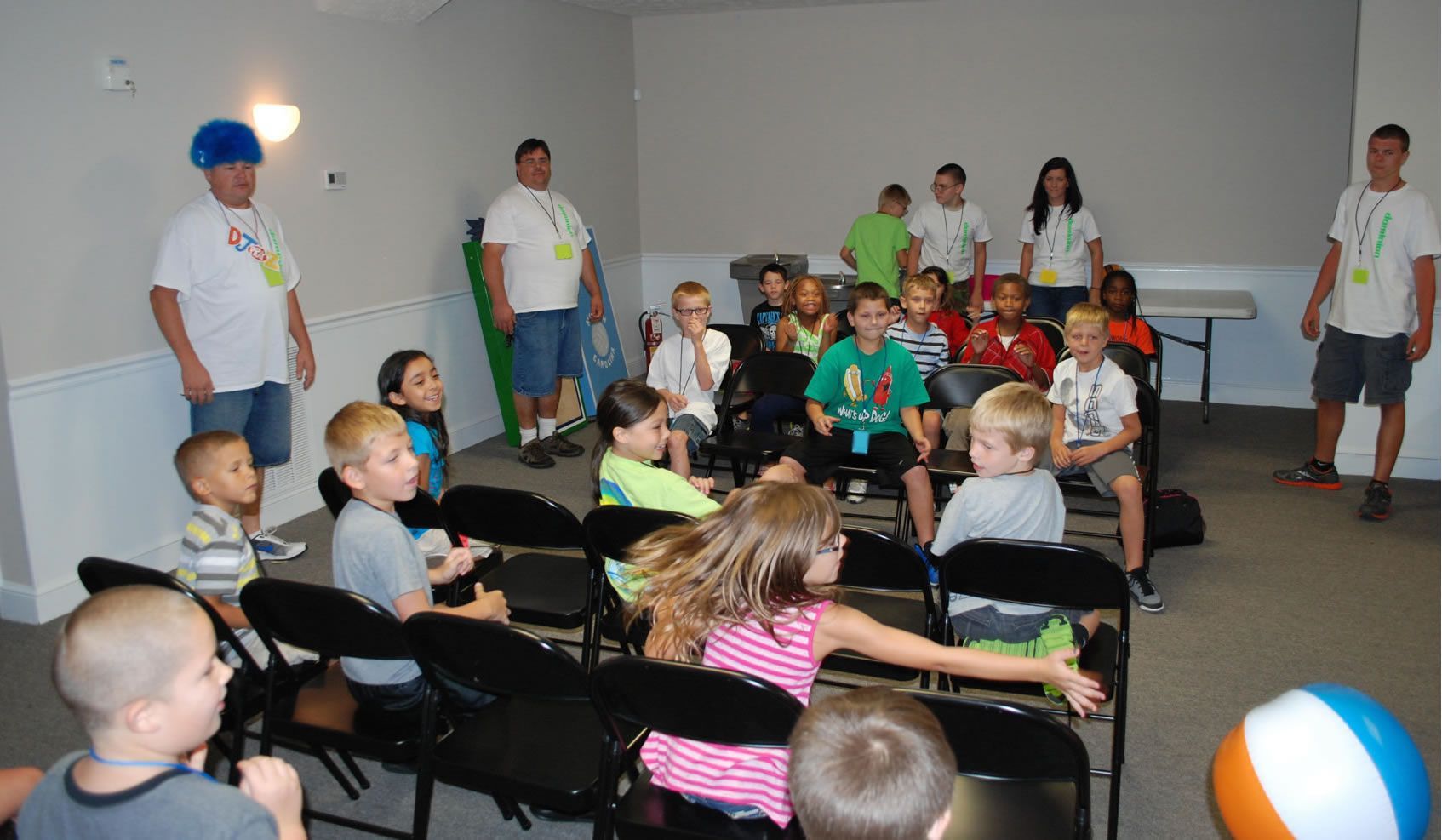 A group of children are sitting in chairs in a room.