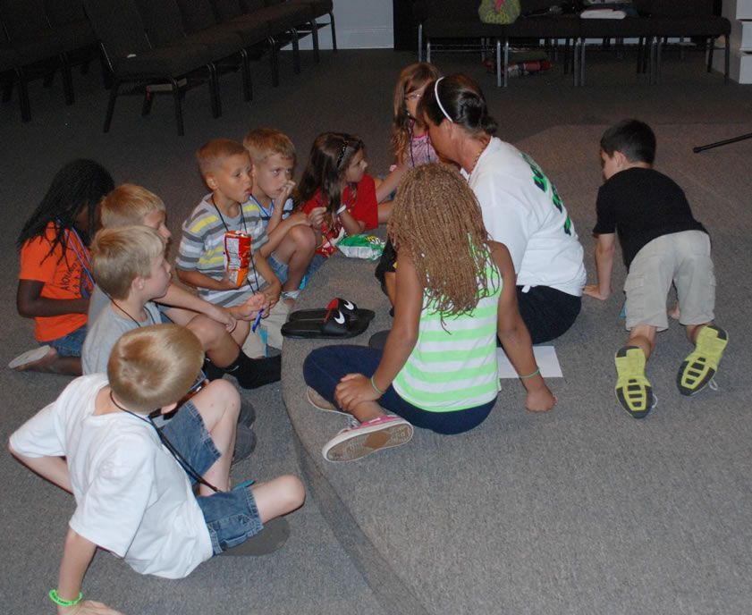A group of children are sitting on the floor in a circle