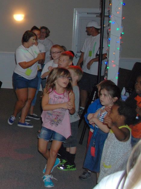 A group of children are dancing in a room.