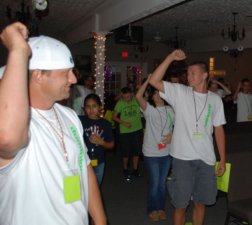 A man wearing a white hat is raising his fist in the air