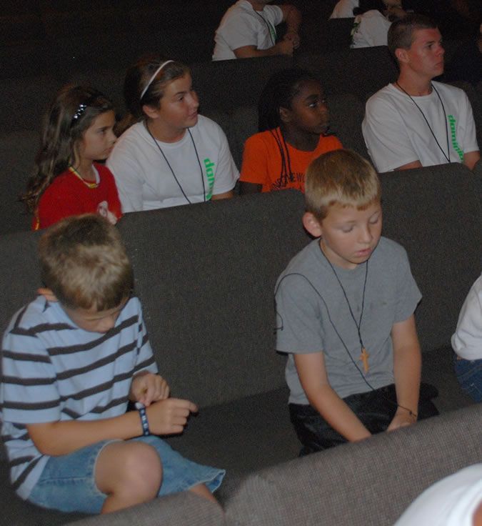 A group of children are sitting in a row wearing name tags that say group
