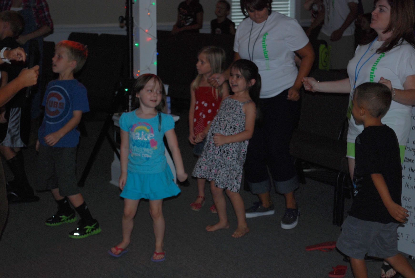 A group of children are dancing in a room.