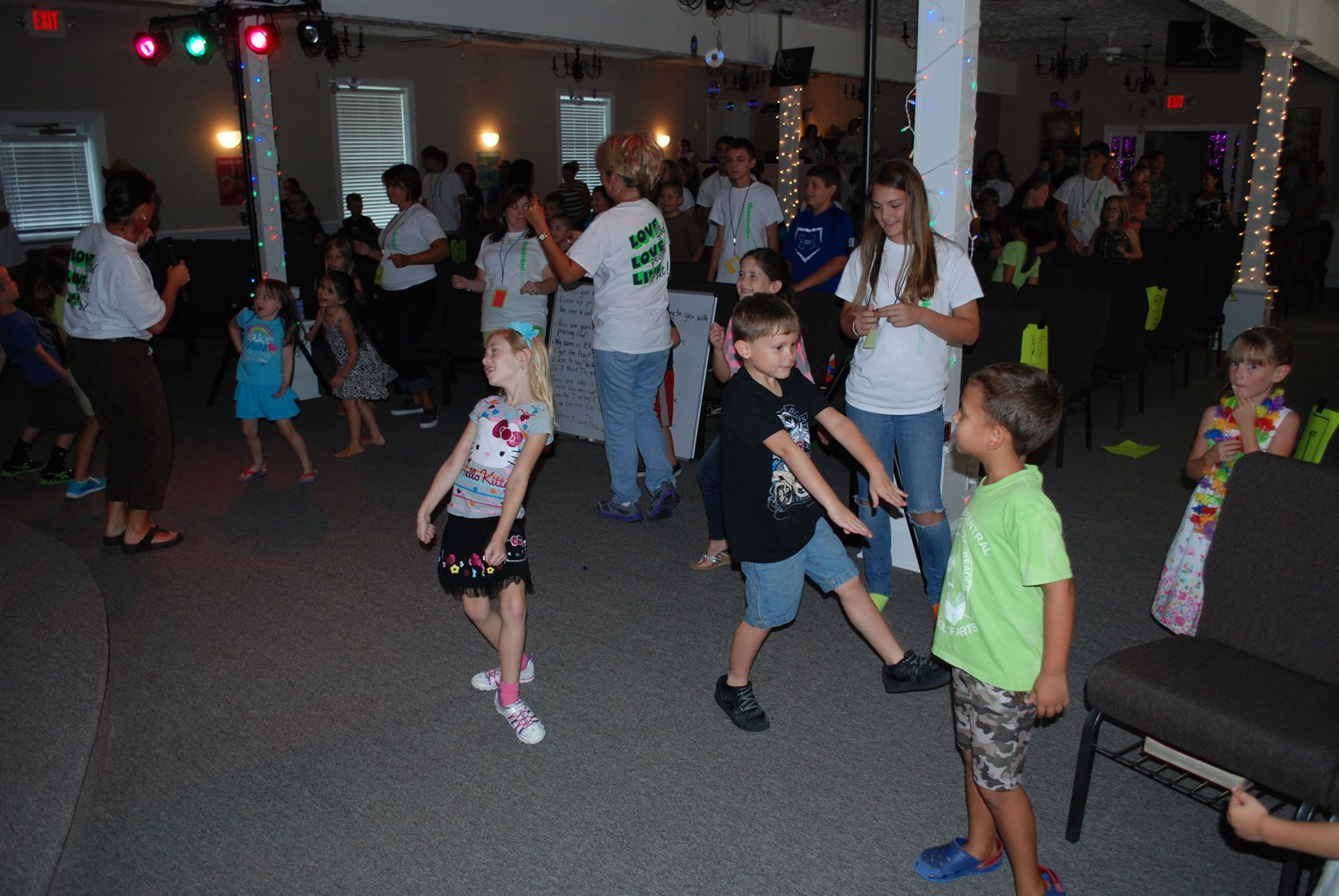 A group of children are dancing in a room.