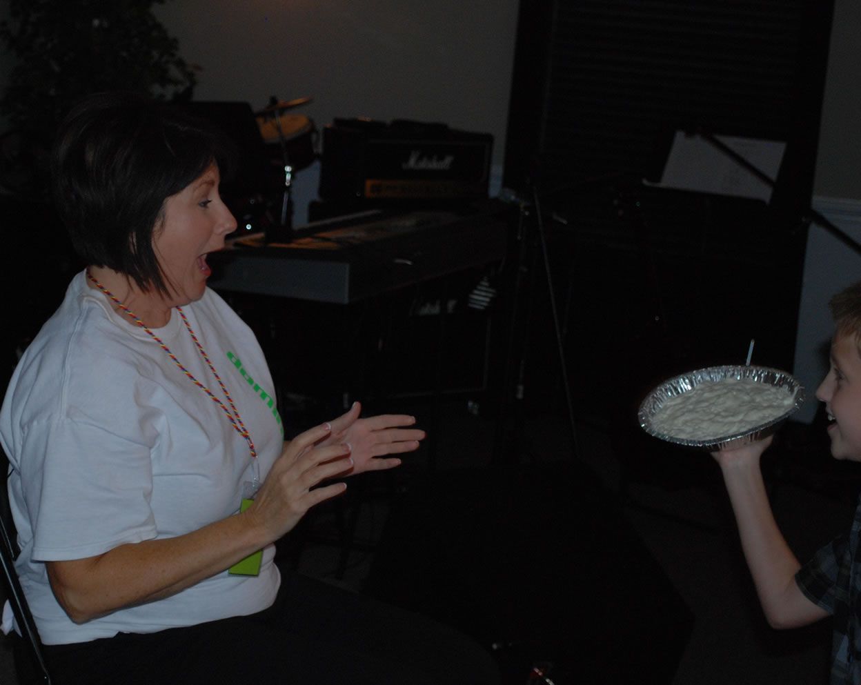 A woman sitting next to a boy holding a plate of food
