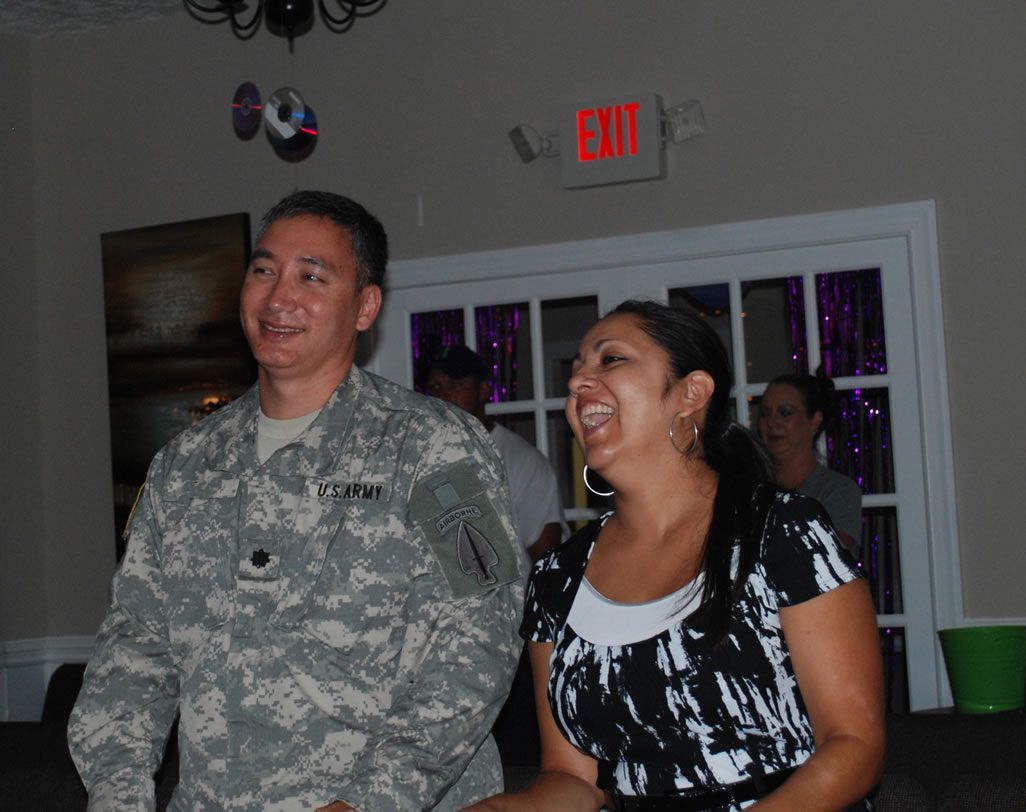 A man in a military uniform stands next to a woman in front of an exit sign