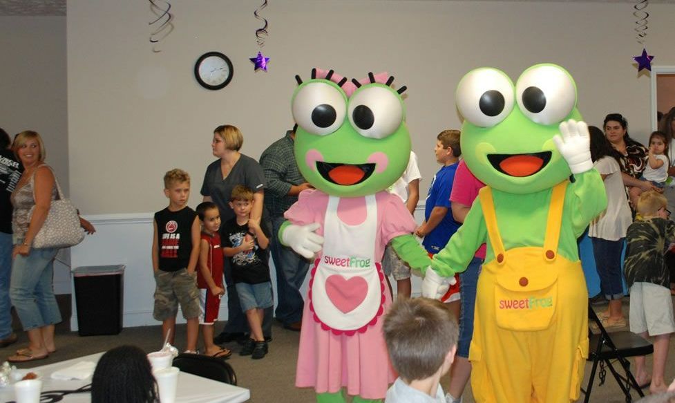 A couple of frog mascots standing next to each other