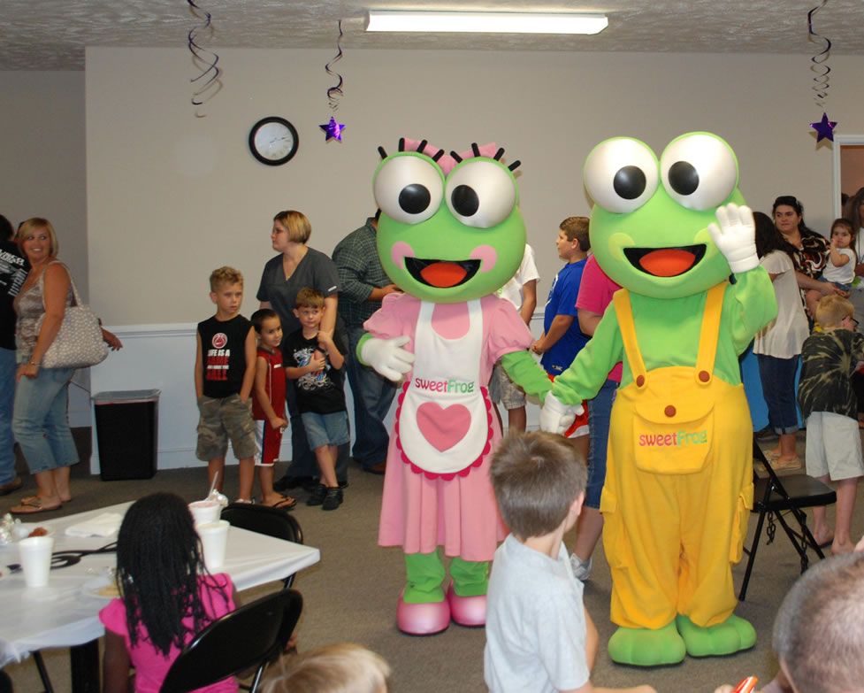 A couple of frog mascots standing next to each other