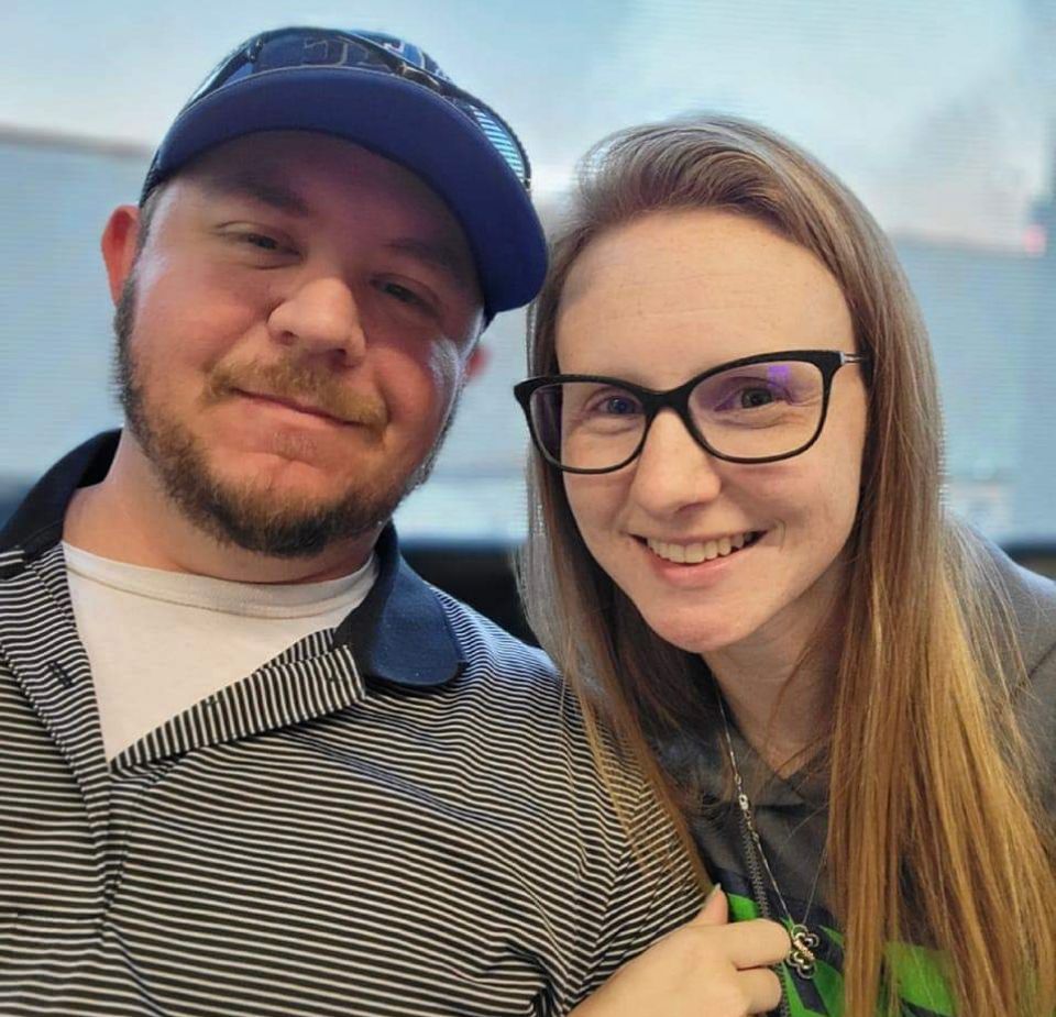 A man and a woman wearing glasses are posing for a picture.