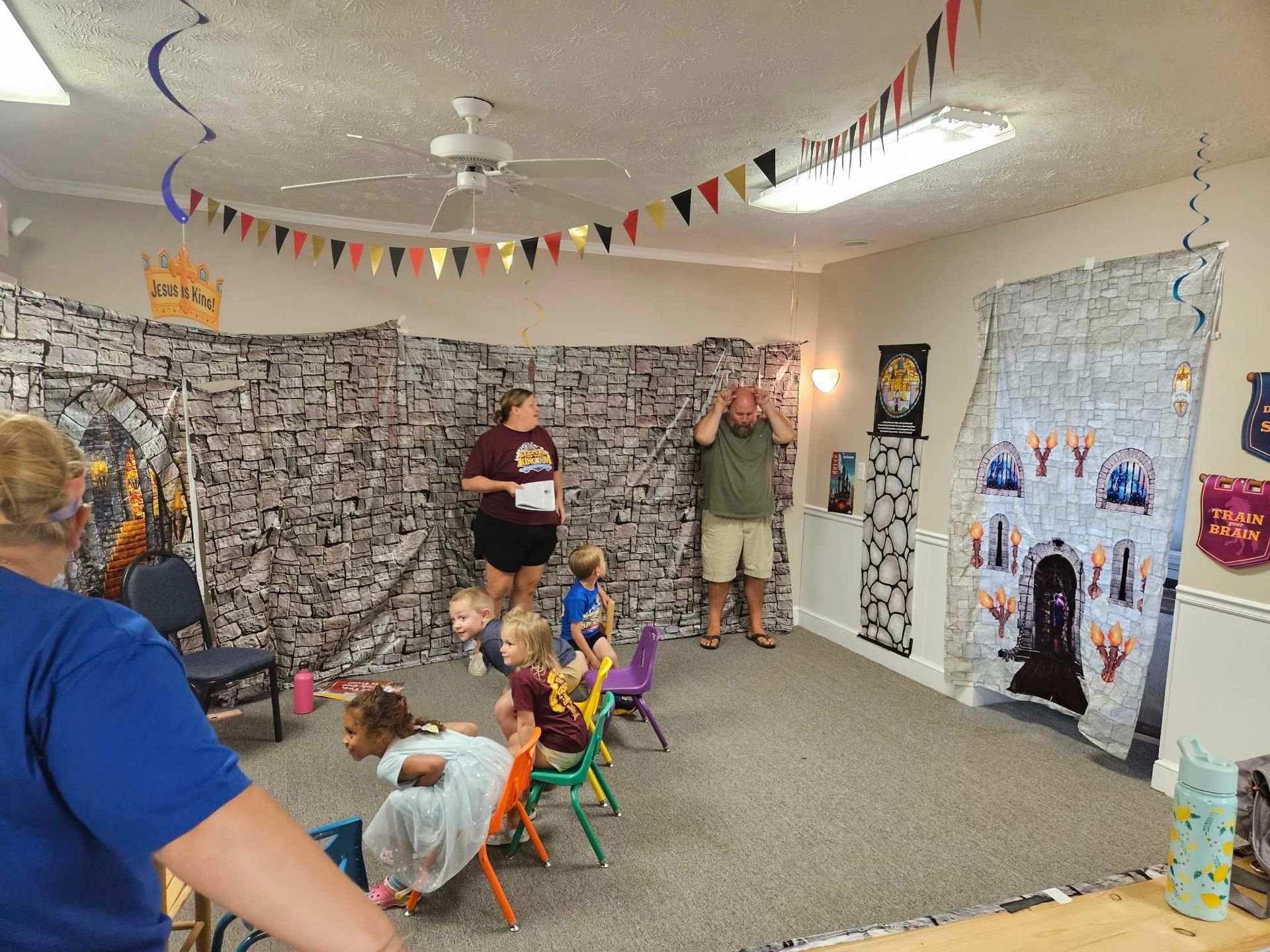 A group of people are standing in a room with a castle decoration.
