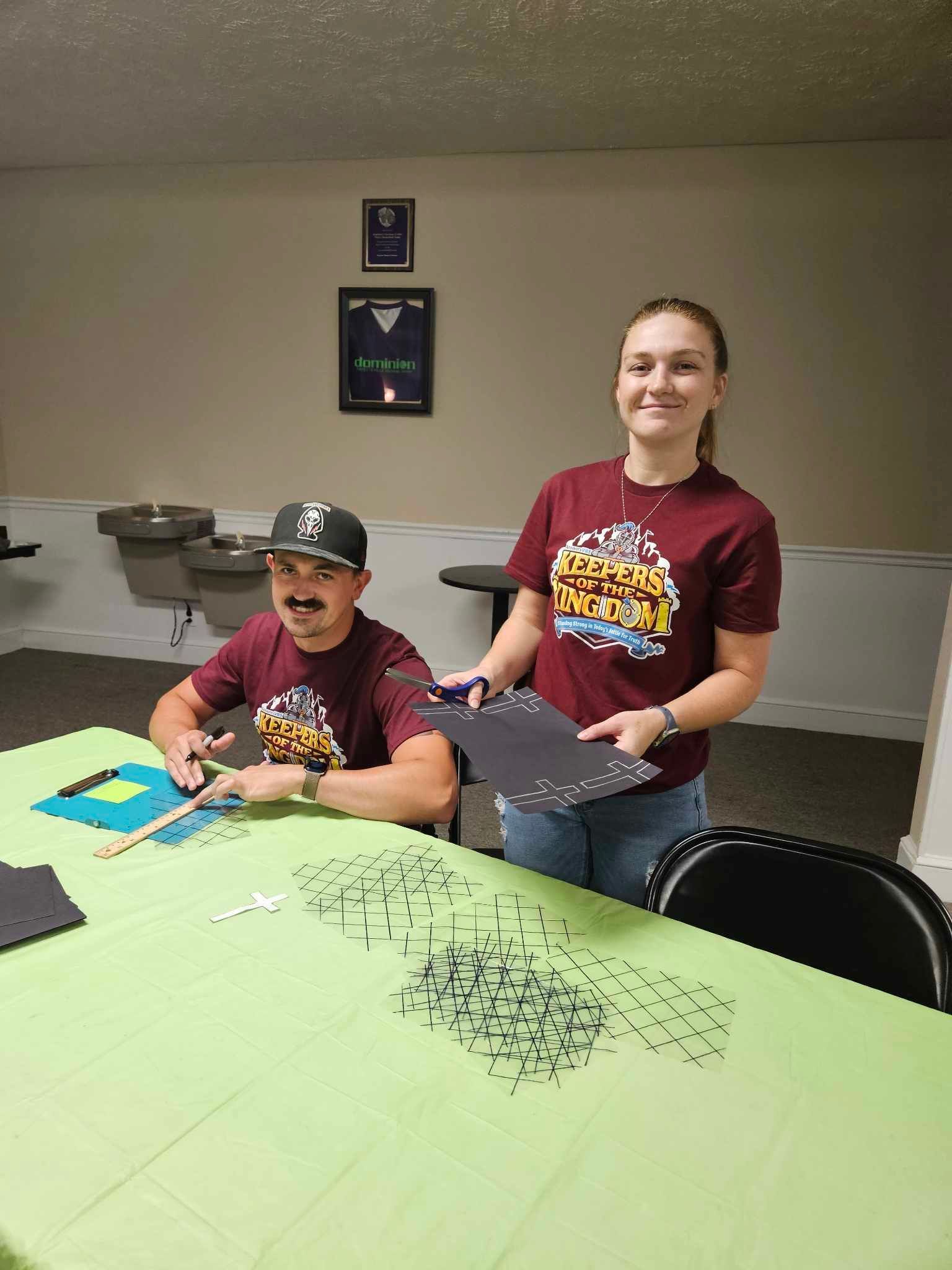 A man and a woman are sitting at a table in a room.