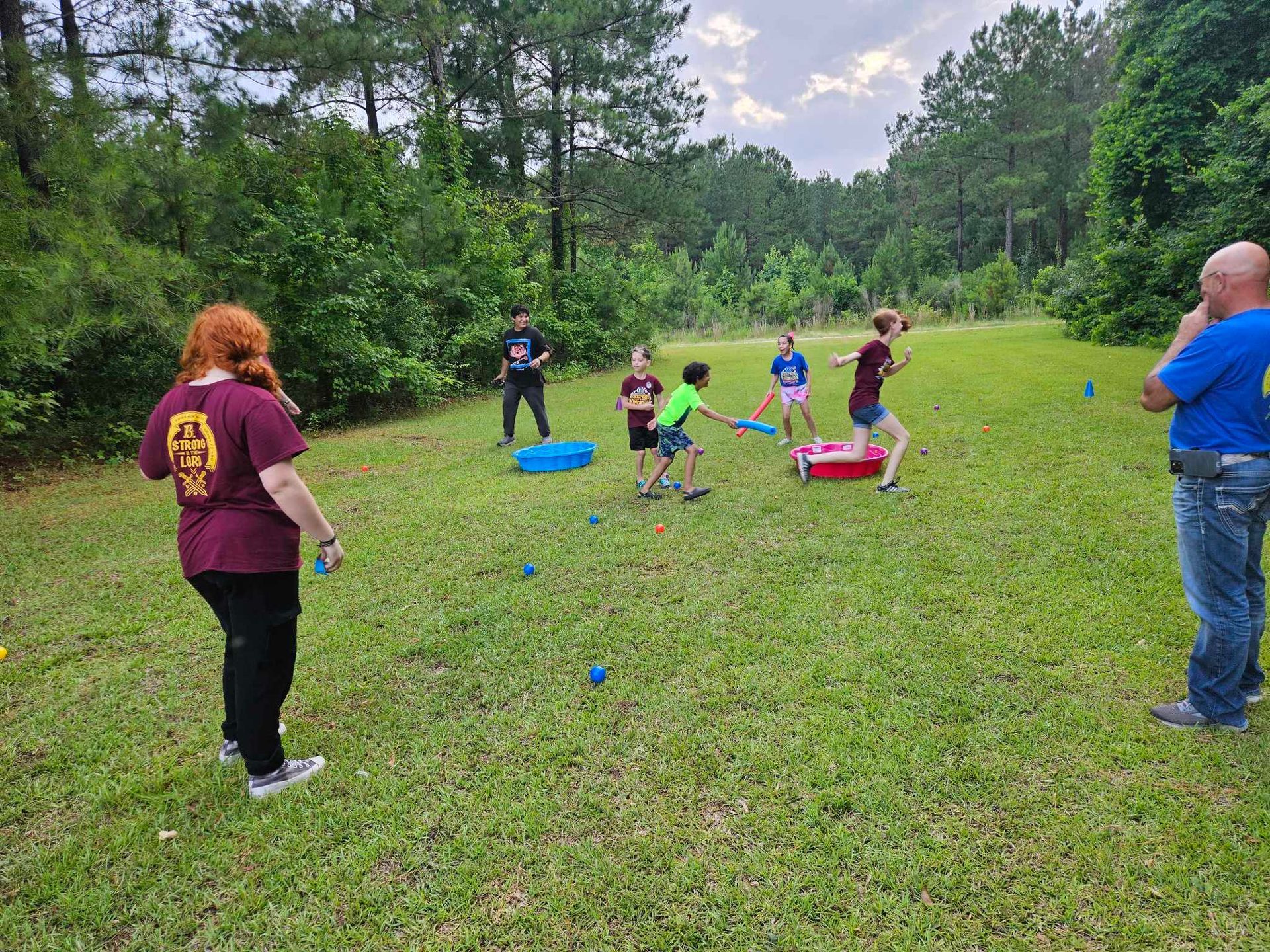 A group of people are playing a game in a grassy field.