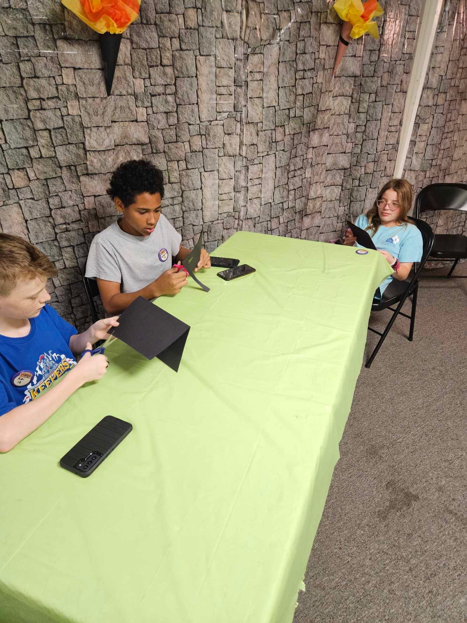 A group of children are sitting at a table making crafts.