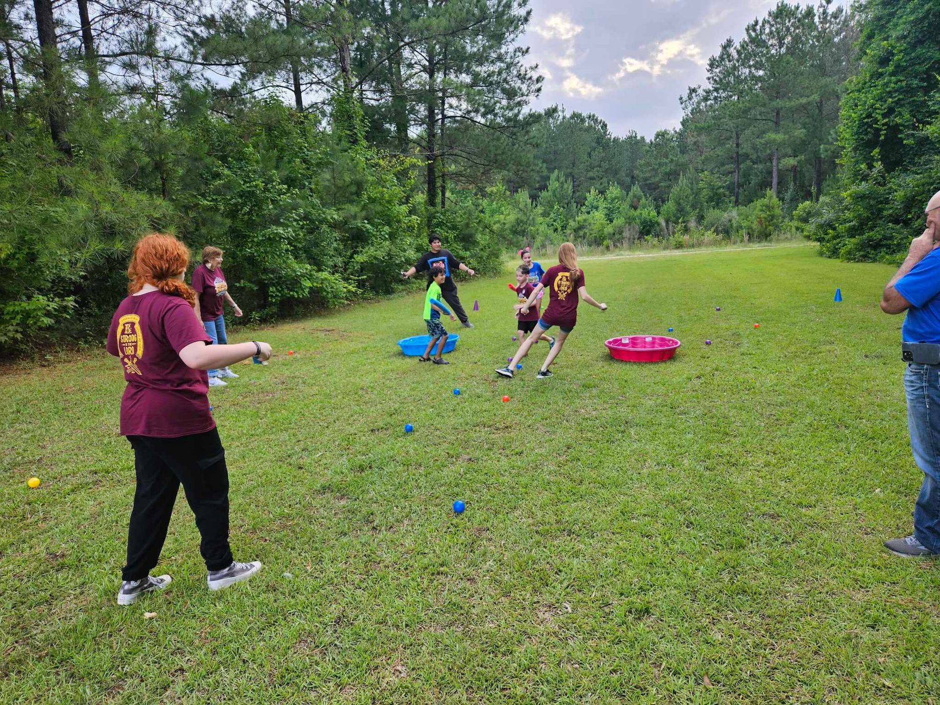 A group of people are playing a game in a grassy field.