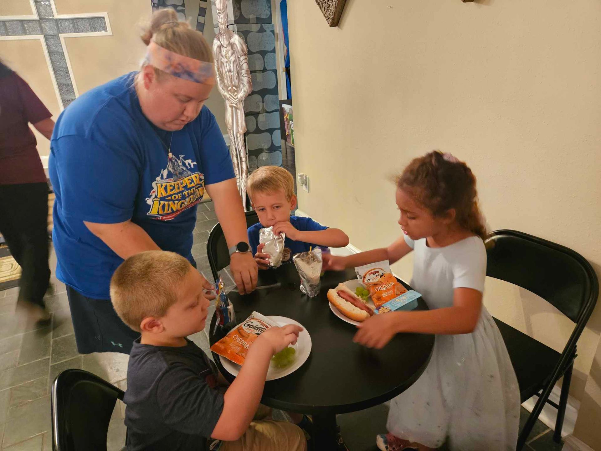 A group of children are sitting at a table eating food.