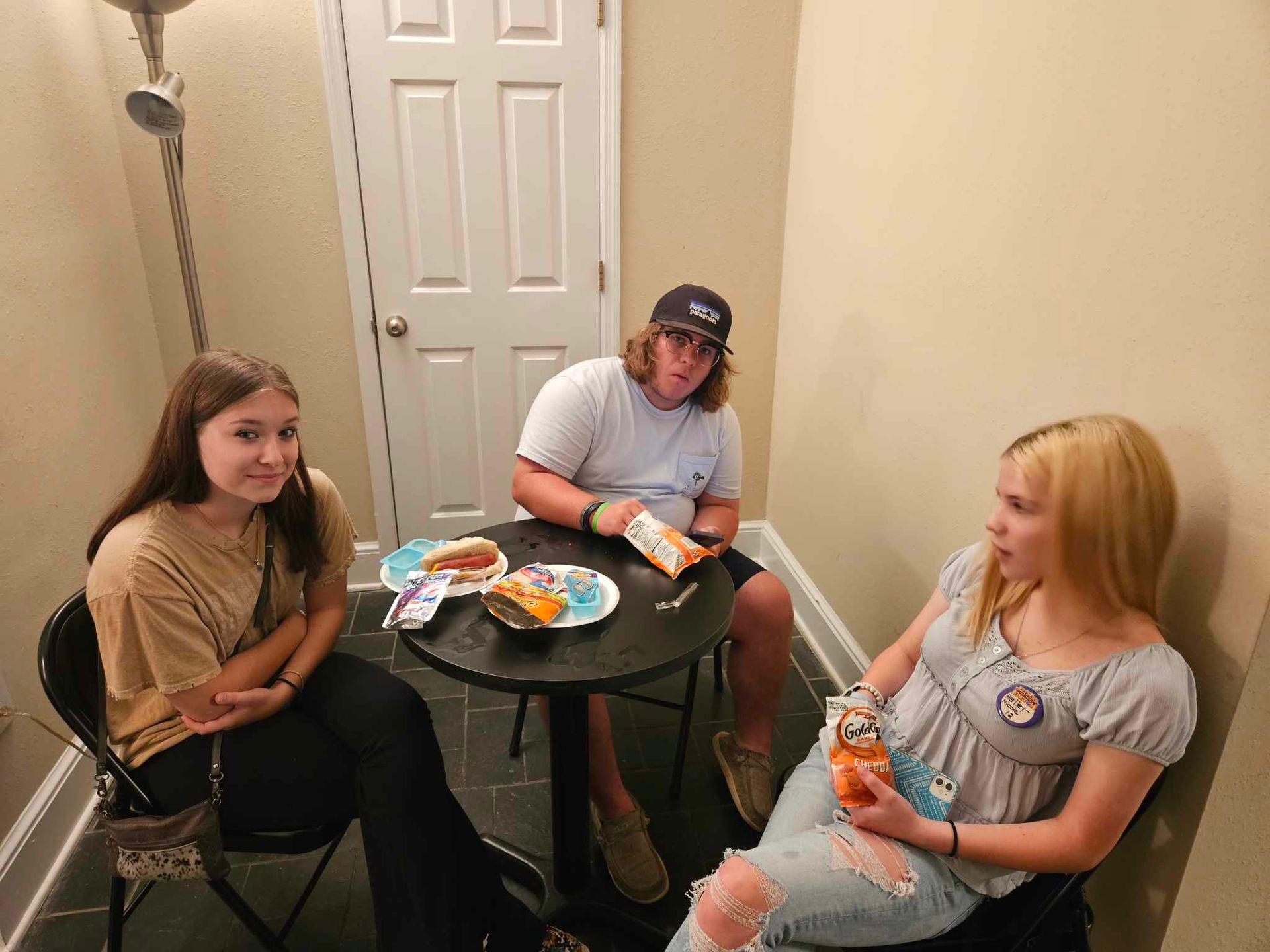 A group of people are sitting around a table eating food.
