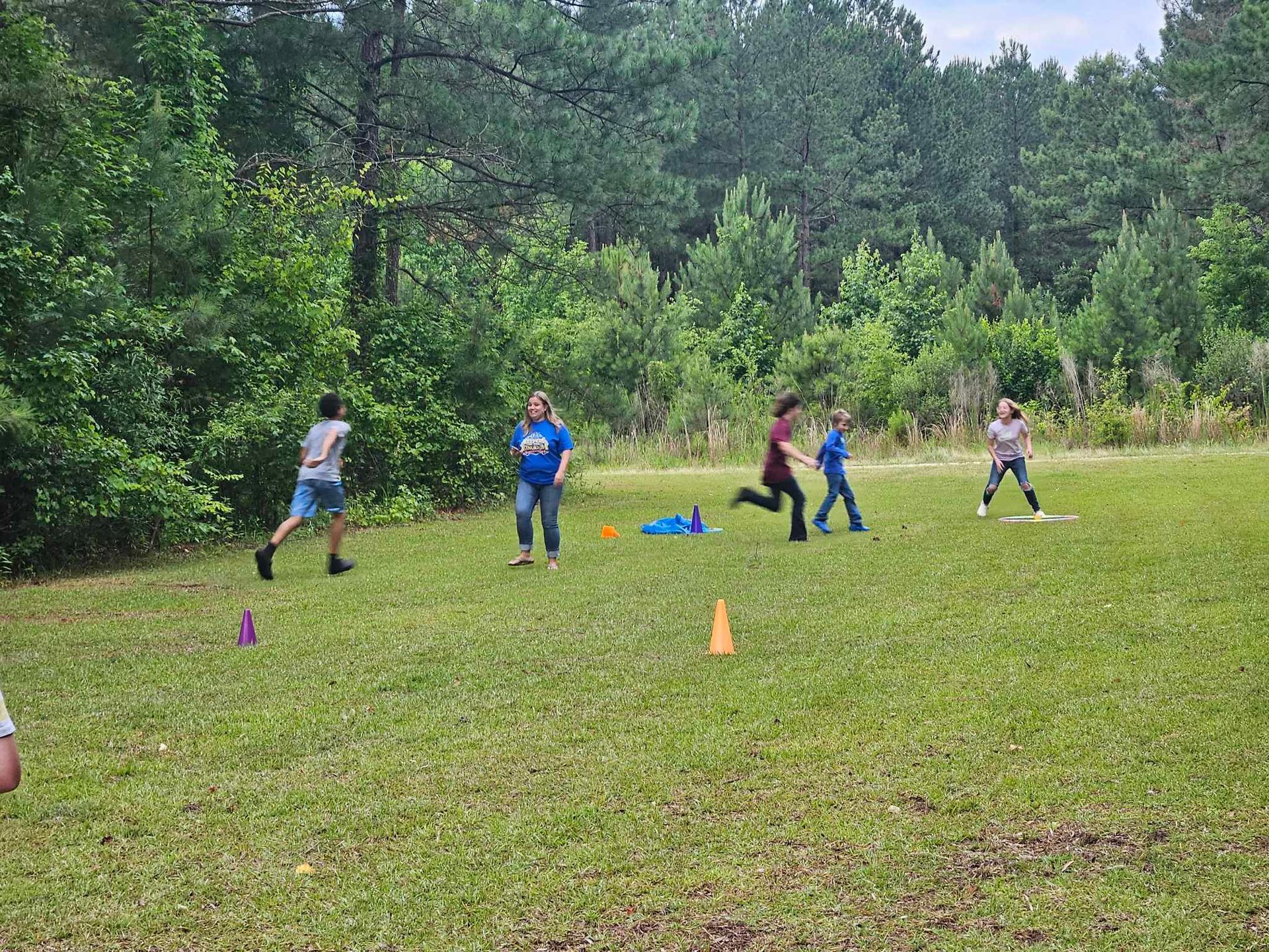 A group of children are playing in a grassy field.