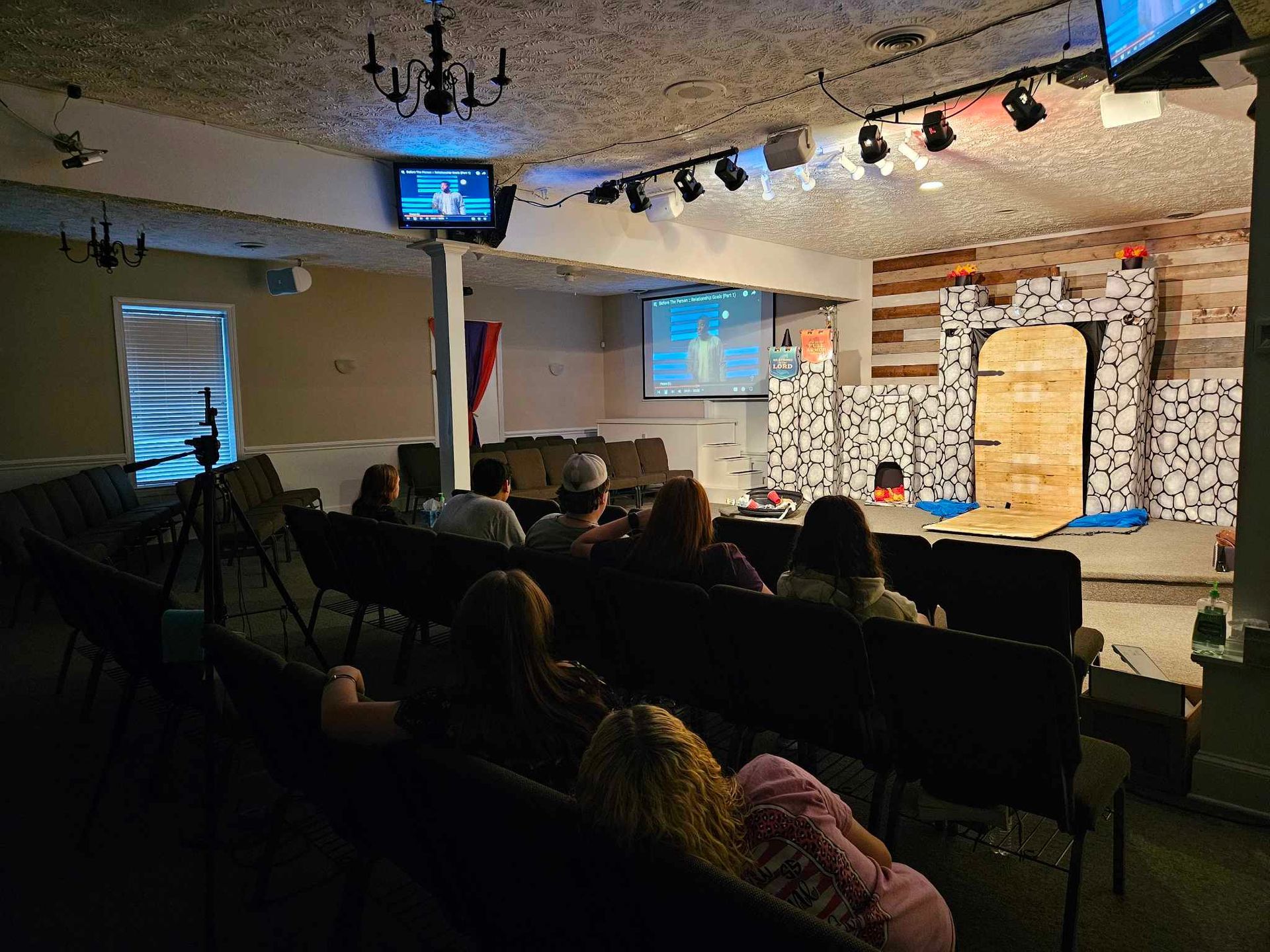 A group of people are sitting in a theater watching a movie.