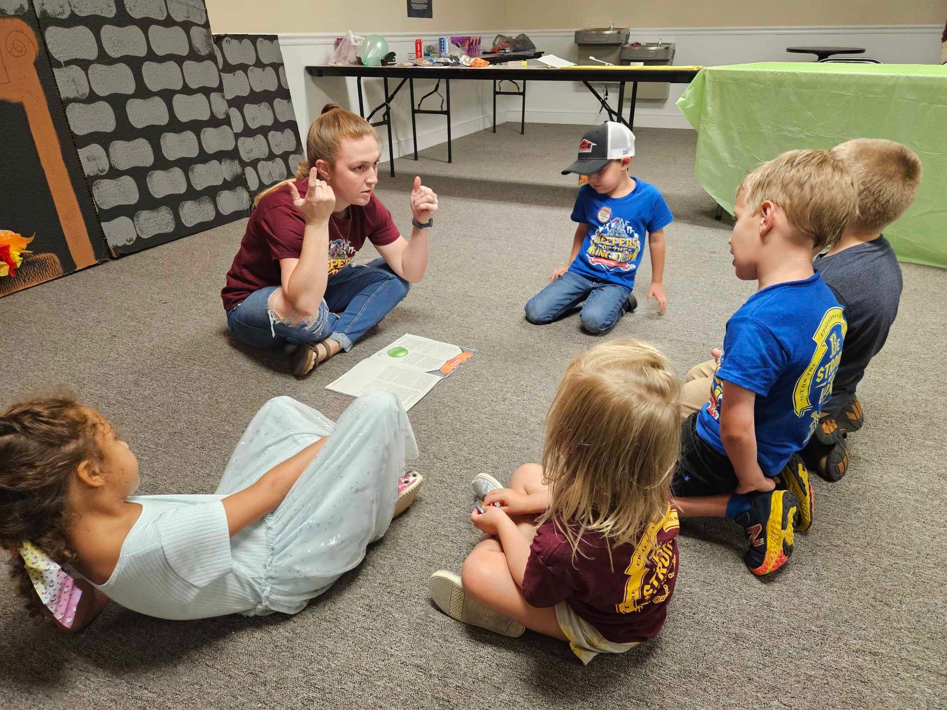 A group of children are sitting in a circle on the floor.