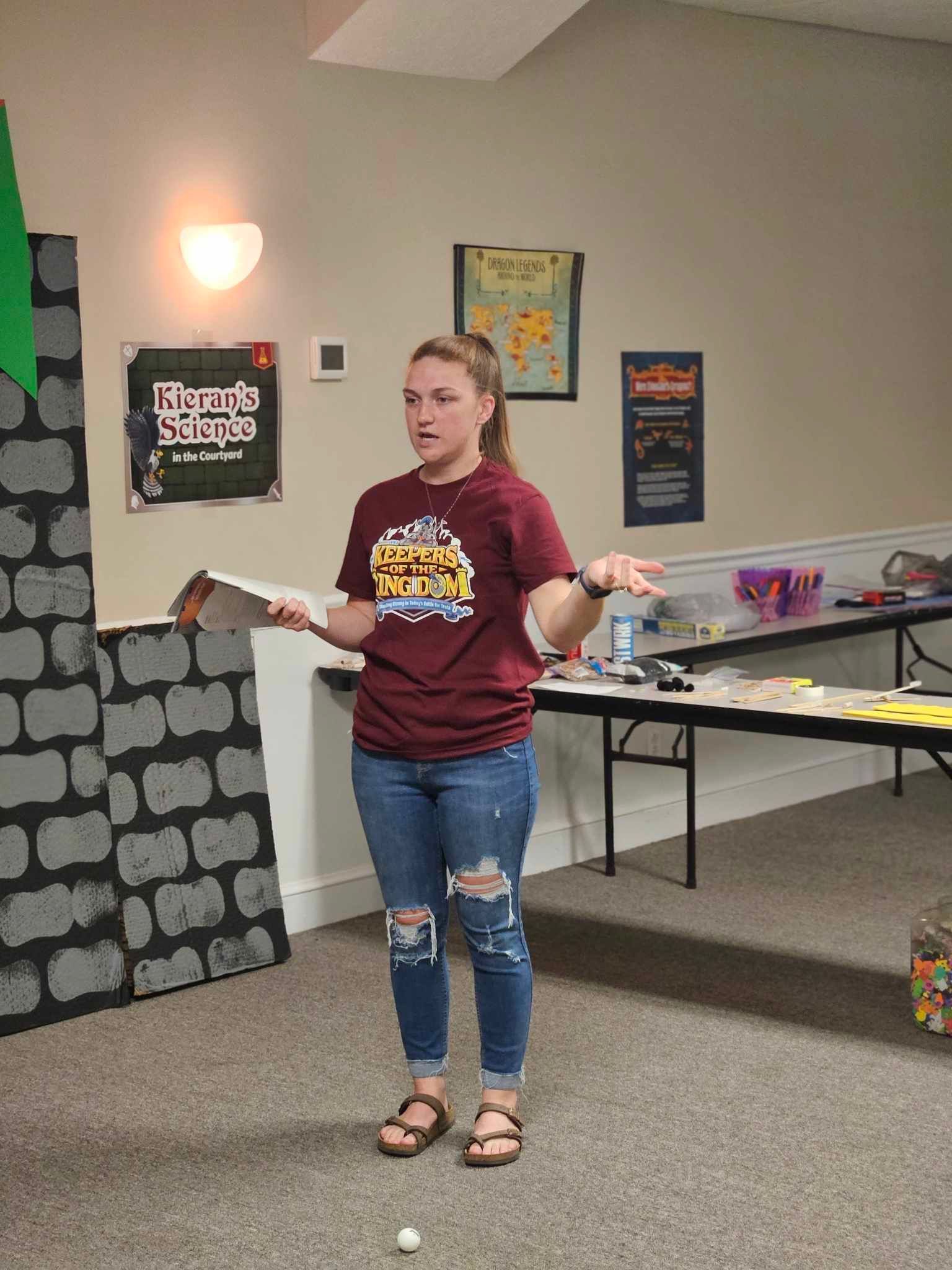 A woman is standing in a room holding a piece of paper.