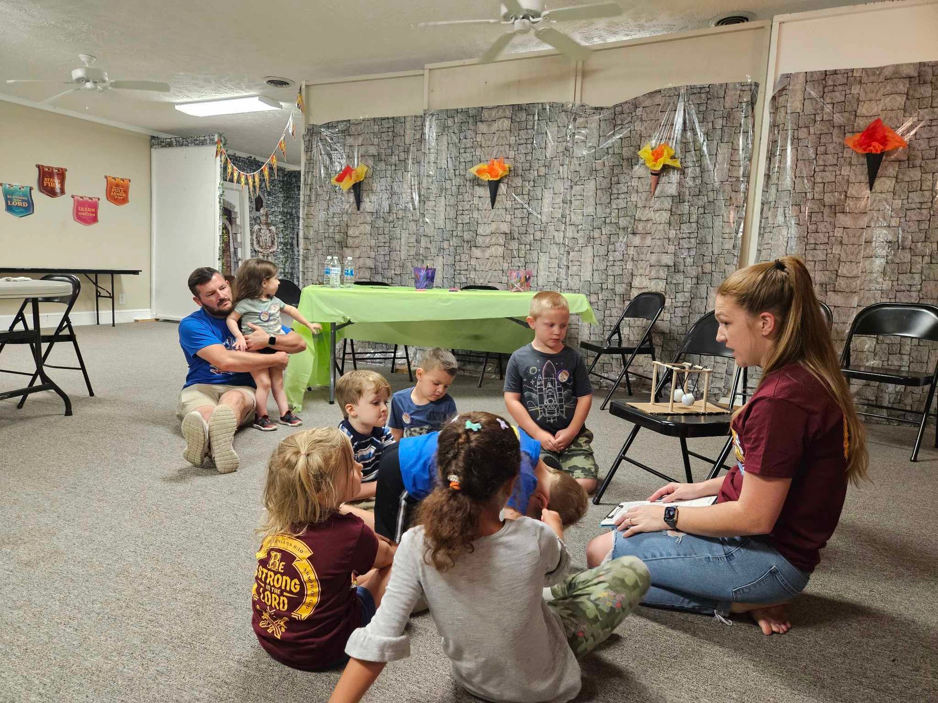 A group of children are sitting on the floor in a room.
