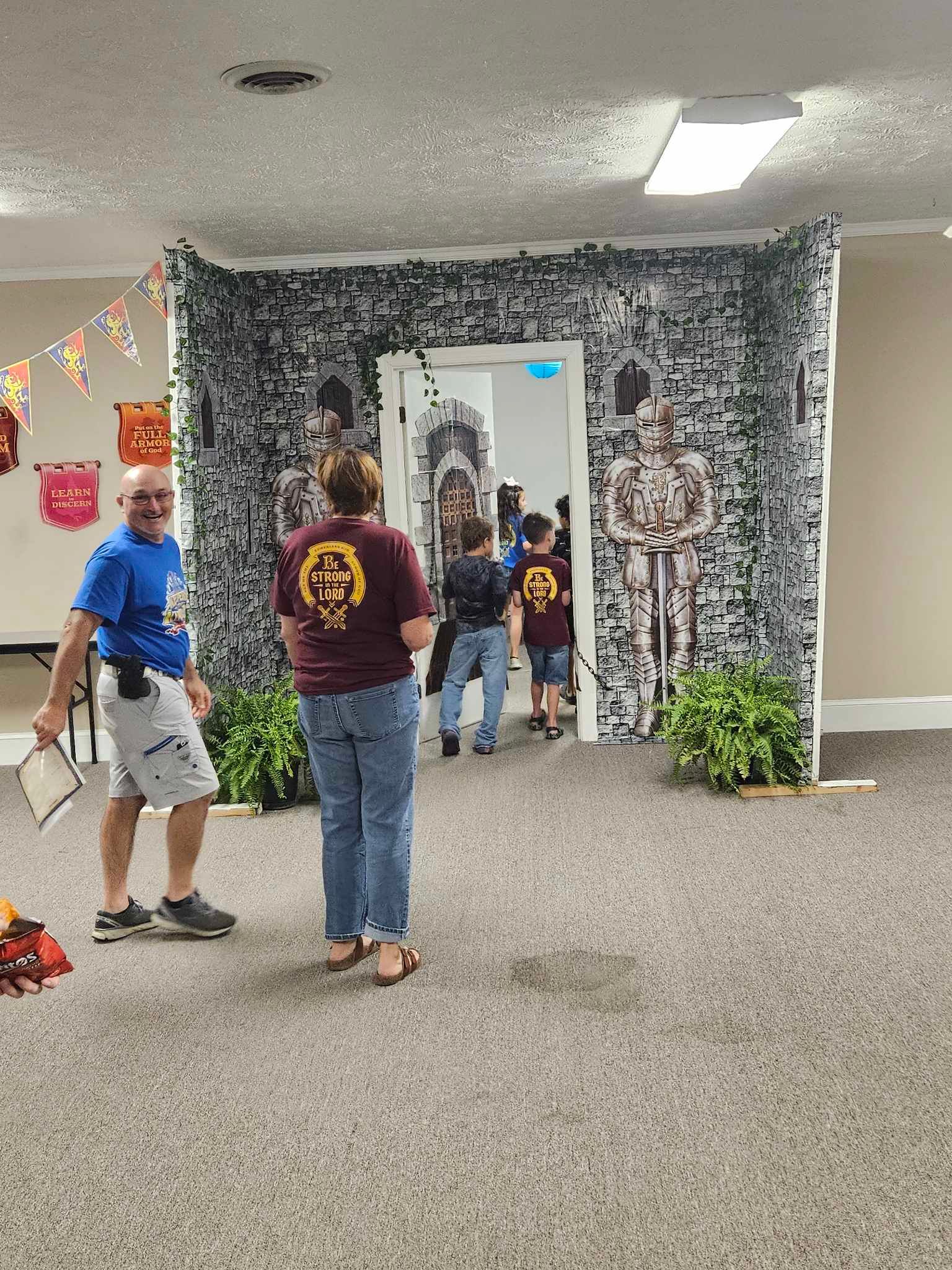A group of people are standing in a room with skeletons on the wall.