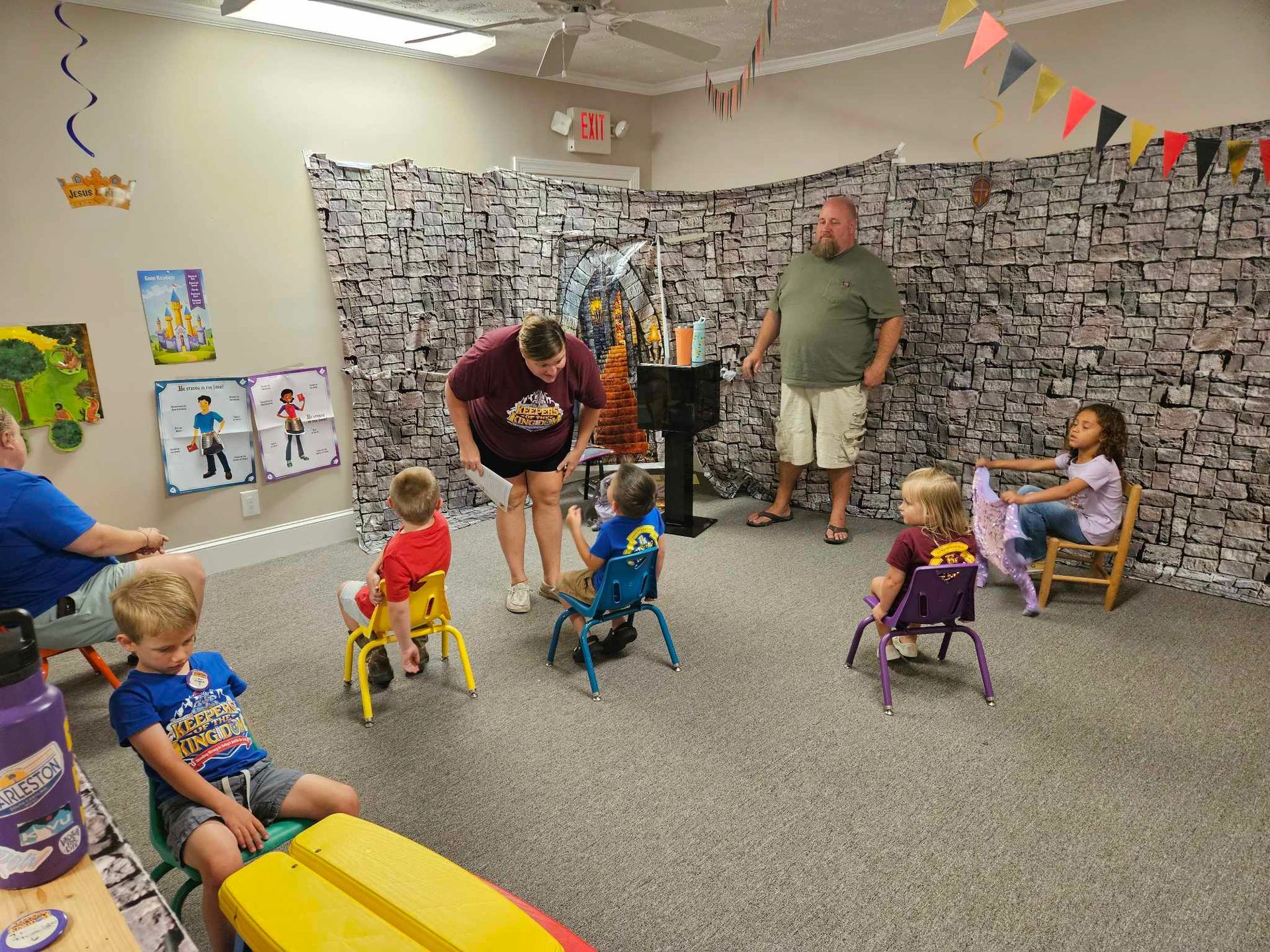 A group of children are sitting in chairs in a room.