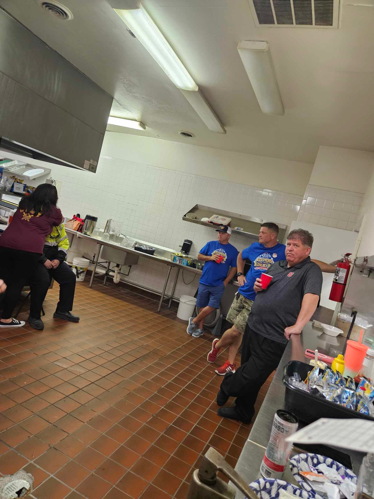 A group of people are standing in a kitchen.