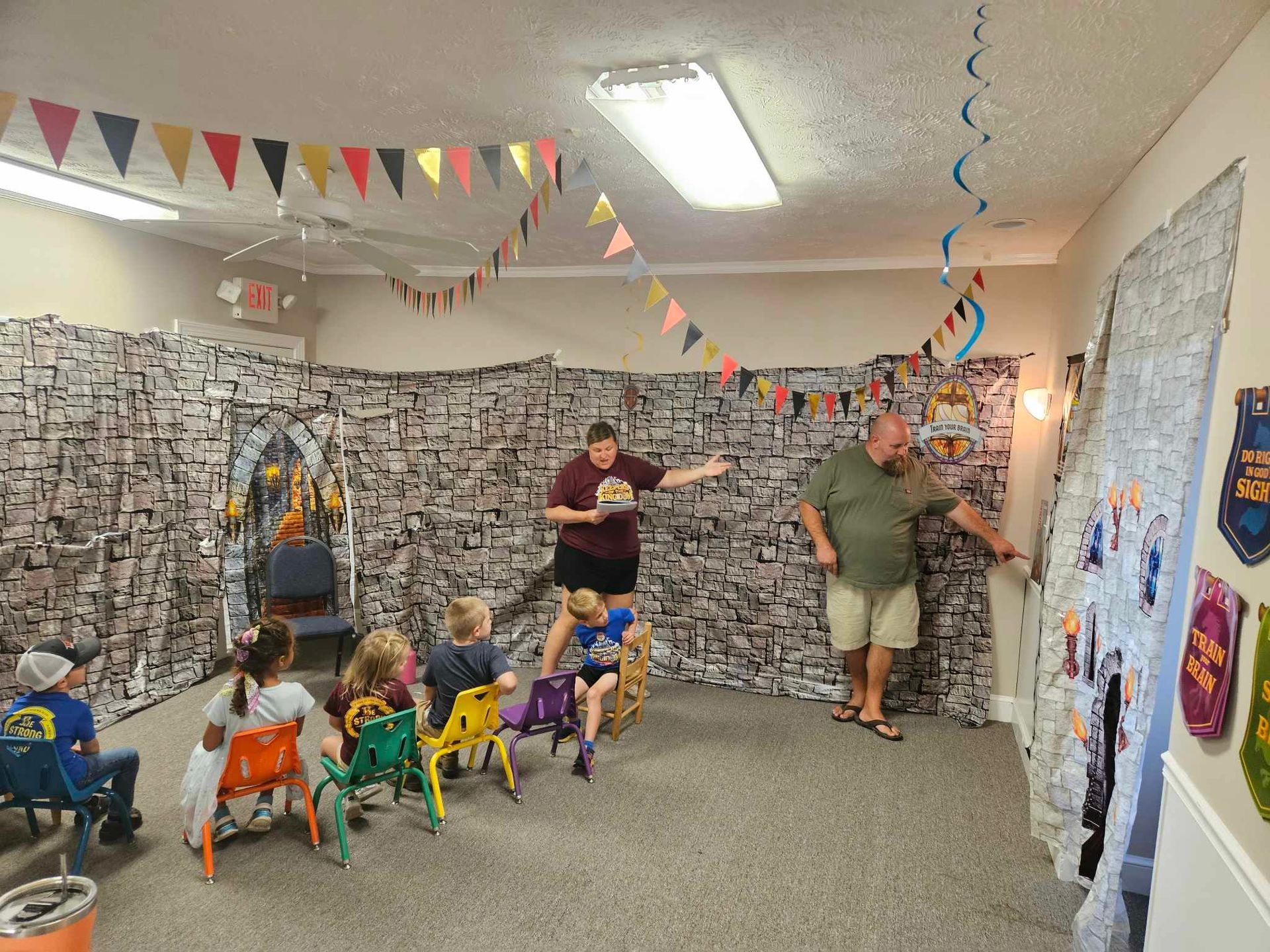 A group of children are sitting in chairs in a room.