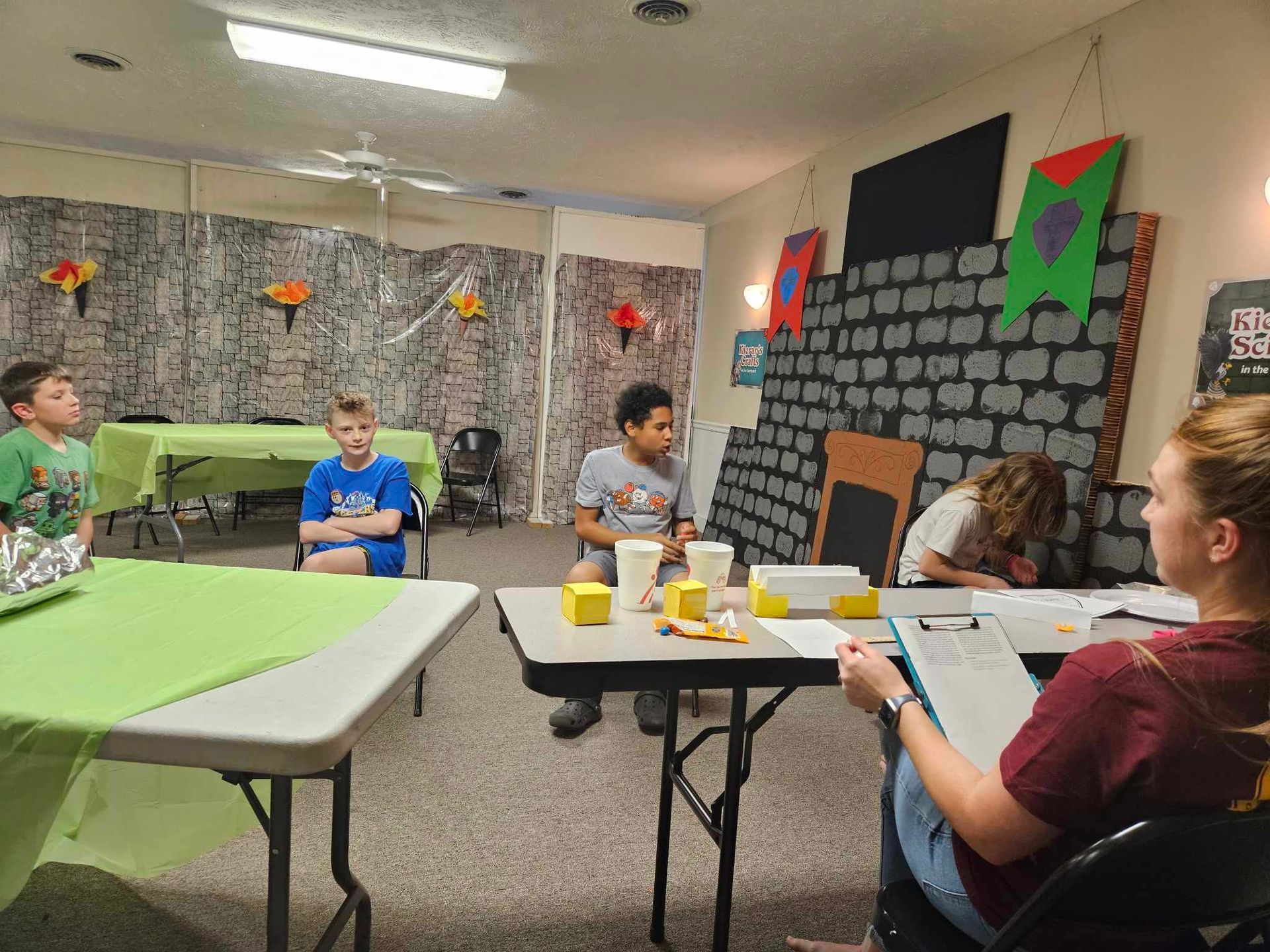 A group of children are sitting at tables in a room.
