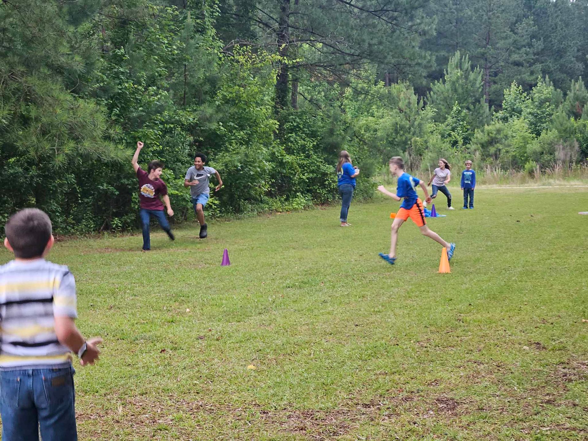 A group of children are playing frisbee in a grassy field.