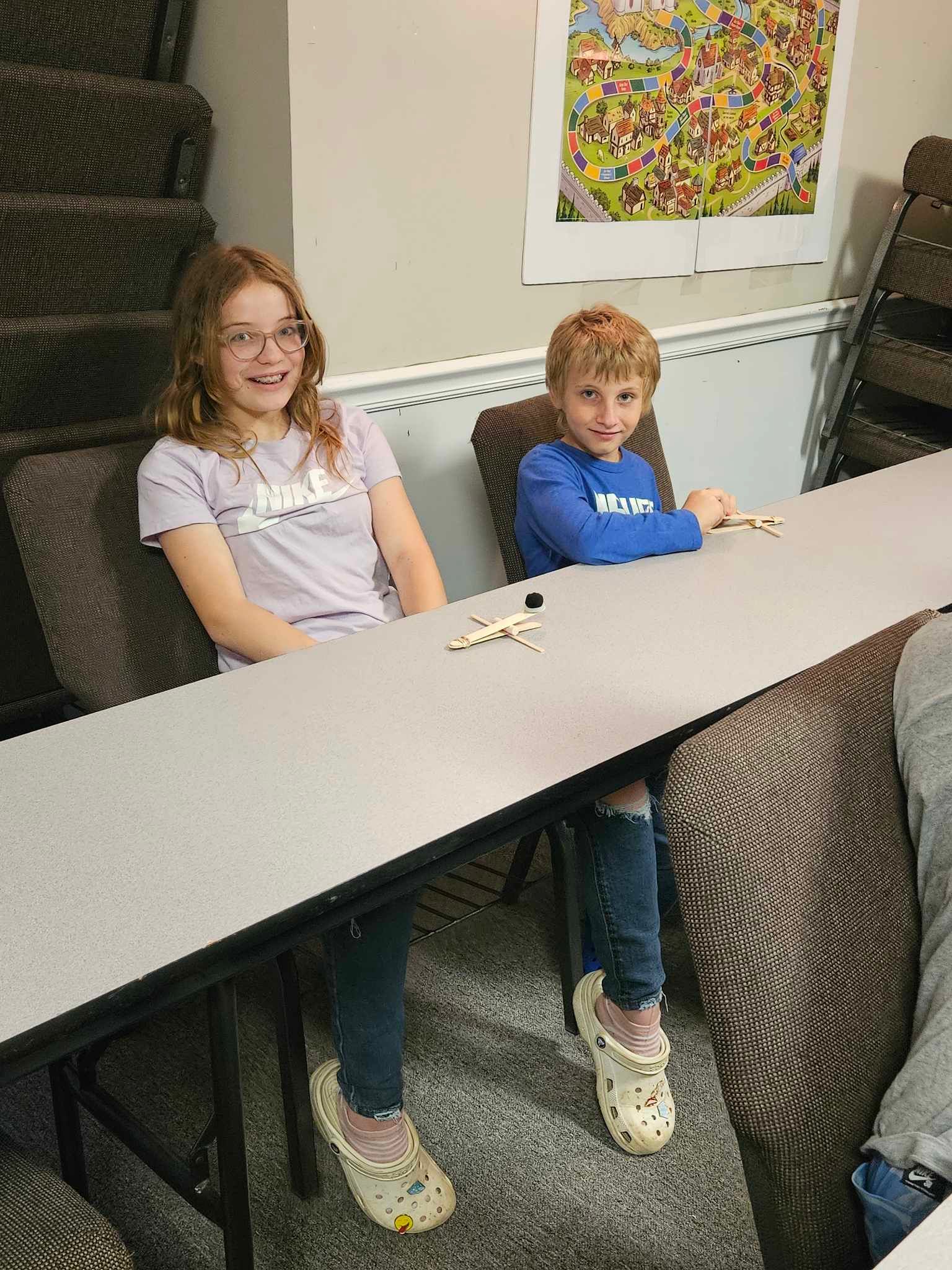 A boy and a girl are sitting at a table.