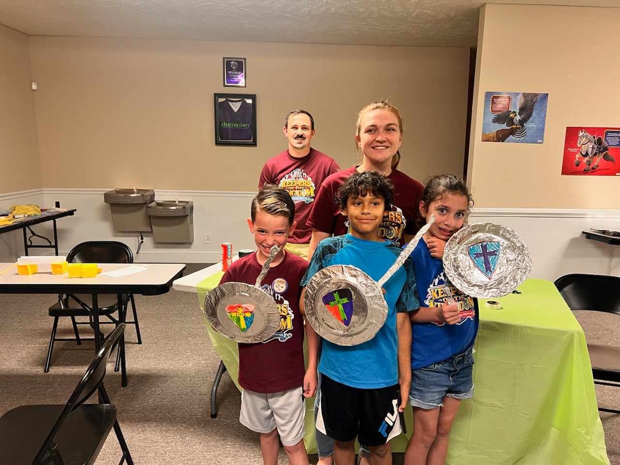 A group of children are standing in a room holding paper plates.
